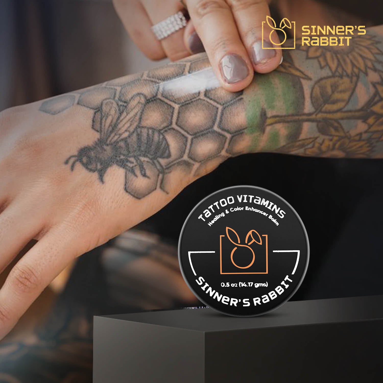 Tattoo Vitamins Box of 24 Tins in half oz, using on a tattooed hand
