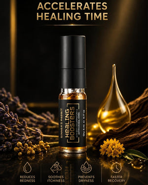 A small cylindrical bottle of Healing Boosters essential oil serum stands centered on a dark reflective surface, surrounded by dried lavender, yellow flowers, wood bark, and a gold droplet-shaped glass vessel. Text at the top reads 'ACCELERATES HEALING TIME' and the bottle label shows 'Healing Boosters' with additional product details.